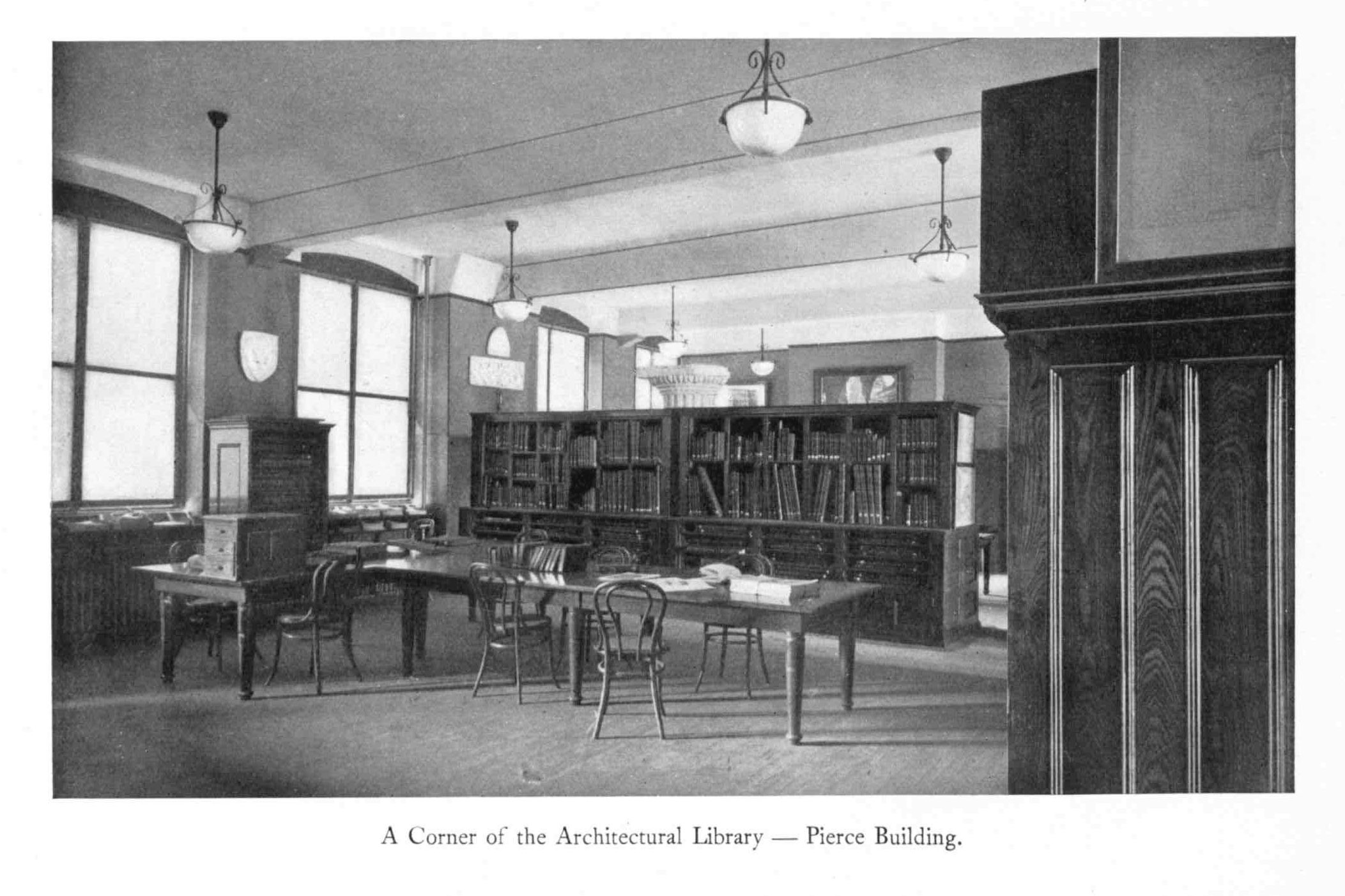 photo of a wood paneled study room with the caption "A corner of the Architectural Library __Pierce building"